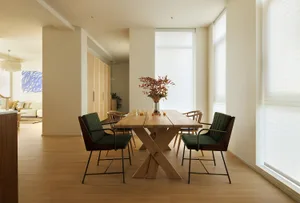 A contemporary dining room featuring a wooden table and chairs with minimalist design elements.