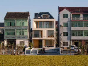 Modern residential house made of concrete materials, featuring large windows and a minimalist design.