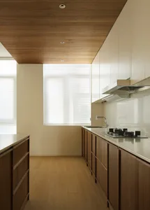 Modern residential kitchen featuring wooden cabinets and a glass backsplash.