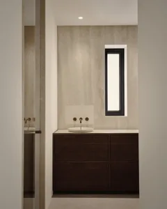 A modern bathroom vanity area with a concrete sink and countertop, featuring a minimalist design.