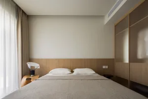 Modern minimalist bedroom with a bed, headboard, and minimalistic design elements.