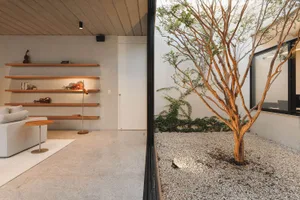 Modern, minimalist living room with concrete flooring and shelving.