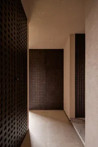 Modern corridor featuring stone paneling and lattice doors