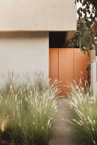 Concrete architectural entryway with a minimalist design and orange glass doors.