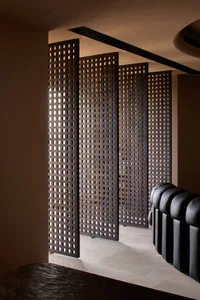 Modern interior design featuring a wooden screen with geometric patterns.