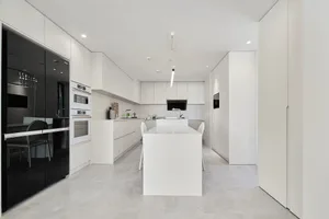 A modern kitchen features elegant marble countertops and white cabinets.