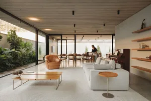 A modern living room with concrete flooring and a leather accent chair.
