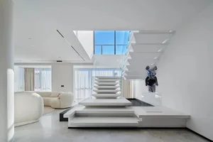 Modern interior design featuring a living room with a glass staircase.