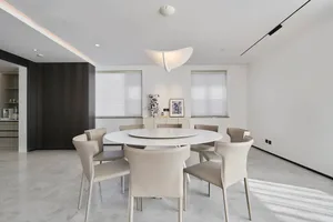 A contemporary living dining room with a white marble table and chairs.