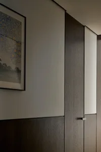 Minimalist interior design featuring wooden cabinets against a white wall.