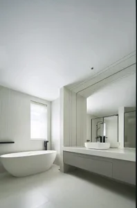 Modern white bathroom with a freestanding bathtub and a floating vanity with a large mirror.