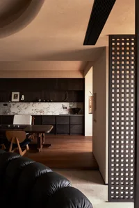 Industrial-themed interior with dark wood elements, marble countertops, and open-plan layout.