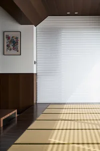 A minimalist interior design featuring a bamboo rug on a wooden floor.