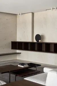 Minimalist living room featuring a concrete structure with modern furniture and decor.
