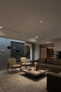 A modern living room featuring a marble coffee table and beige upholstered furniture.