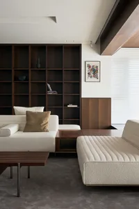 Modern living room featuring wooden furniture and a large bookshelf.