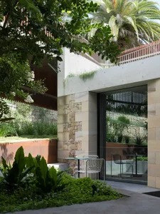 Modern residential exterior featuring concrete, stone, and metal materials.