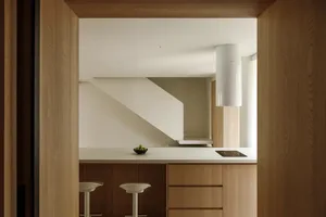 Modern minimalist kitchen with wooden cabinets and a white countertop.