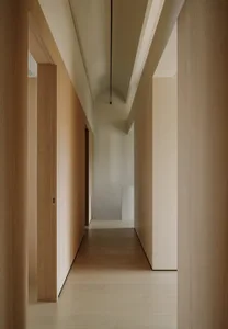 A minimalist corridor with wooden walls and floors, arch-shaped ceiling details, and arch-shaped openings for doors.