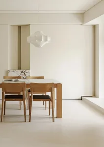 A minimalist dining room featuring modern wood and marble elements, complemented by contemporary lighting fixtures.