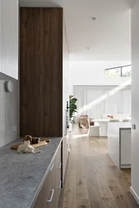 Modern industrial kitchen with wooden cabinetry and marble countertops.