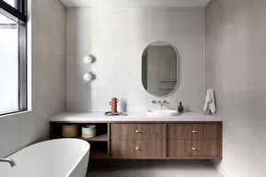 Modern bathroom featuring concrete countertop, wooden vanity, and minimalist design.