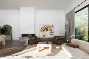 A modern living room with mixed materials, featuring a white couch, brown chairs, and a large abstract painting.