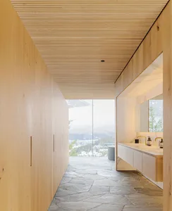 簡約衛浴空間以天然木牆與石材地板為主，遠處可見山景。