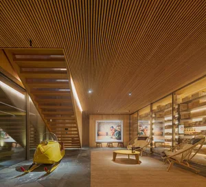 Interior of a modern retail space with wooden finishes and a yellow vintage snowmobile on display.