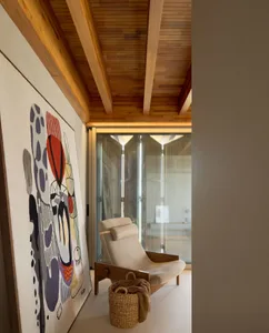 A modern living room featuring a lounge chair, a large abstract artwork, and a woven basket.