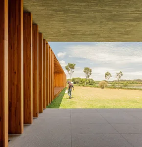 Modern exterior design featuring wooden columns and a concrete ceiling.