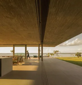 Concrete exterior of a modern residential property with a garden and water view.