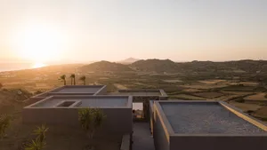 A minimalist residence featuring concrete architecture amidst a scenic landscape.