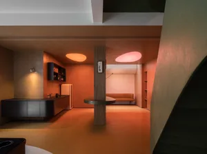Modern living room with concrete walls, Belgian limestone flooring, and steel accents.