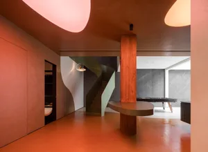 A modern living room featuring concrete, metal, and wooden elements, illuminated by warm, ambient lighting.