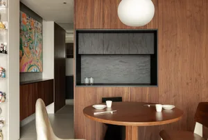 A modern kitchen featuring wooden elements, with a round dining table and chairs.