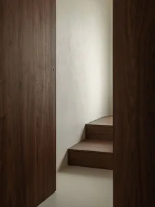 A modern, linear staircase with wooden treads and walls.