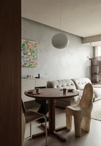 A modern living room with a concrete wall and minimalist furniture.