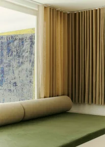 Modern bedroom with textured cushions, soft throw, and blinds