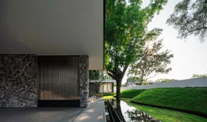 A modern residential facade featuring glass and stone materials.