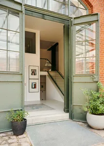 Industrial-style entryway with glass-paneled door and concrete steps.