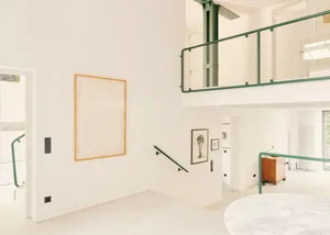Modern apartment with minimalist design, featuring white paneled walls and a clean, open floor plan.