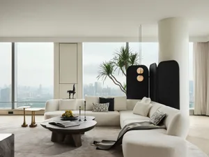 Modern white living room with black accents and a panoramic city view.