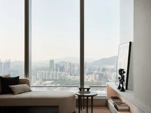 A minimalist room with a large window overlooking a cityscape.