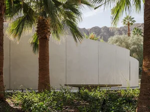 Modern architectural furniture surrounded by lush greenery.