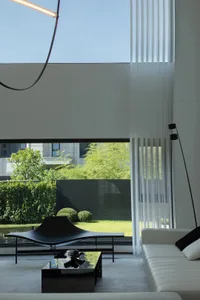 Modern minimalist residential interior showcasing sleek glass, concrete, and textile finishes.
