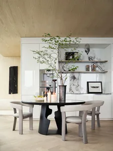 Modern residential kitchen featuring marble countertops, wooden cabinets, and elegant furniture.
