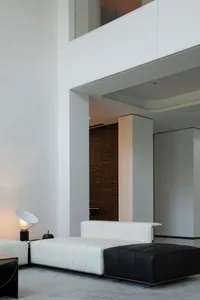 Contemporary living room featuring minimalist design with white and black leather furniture, wood accents, and minimalistic d