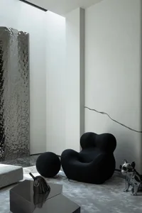 Modern living room with black metallic furniture and abstract art.