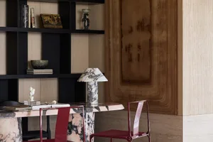 A modern office space featuring a marble desk with chairs.